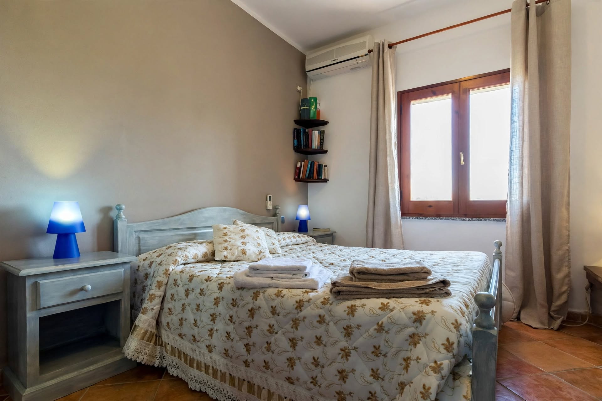 Camera matrimoniale con pareti blu e arredi rustici
